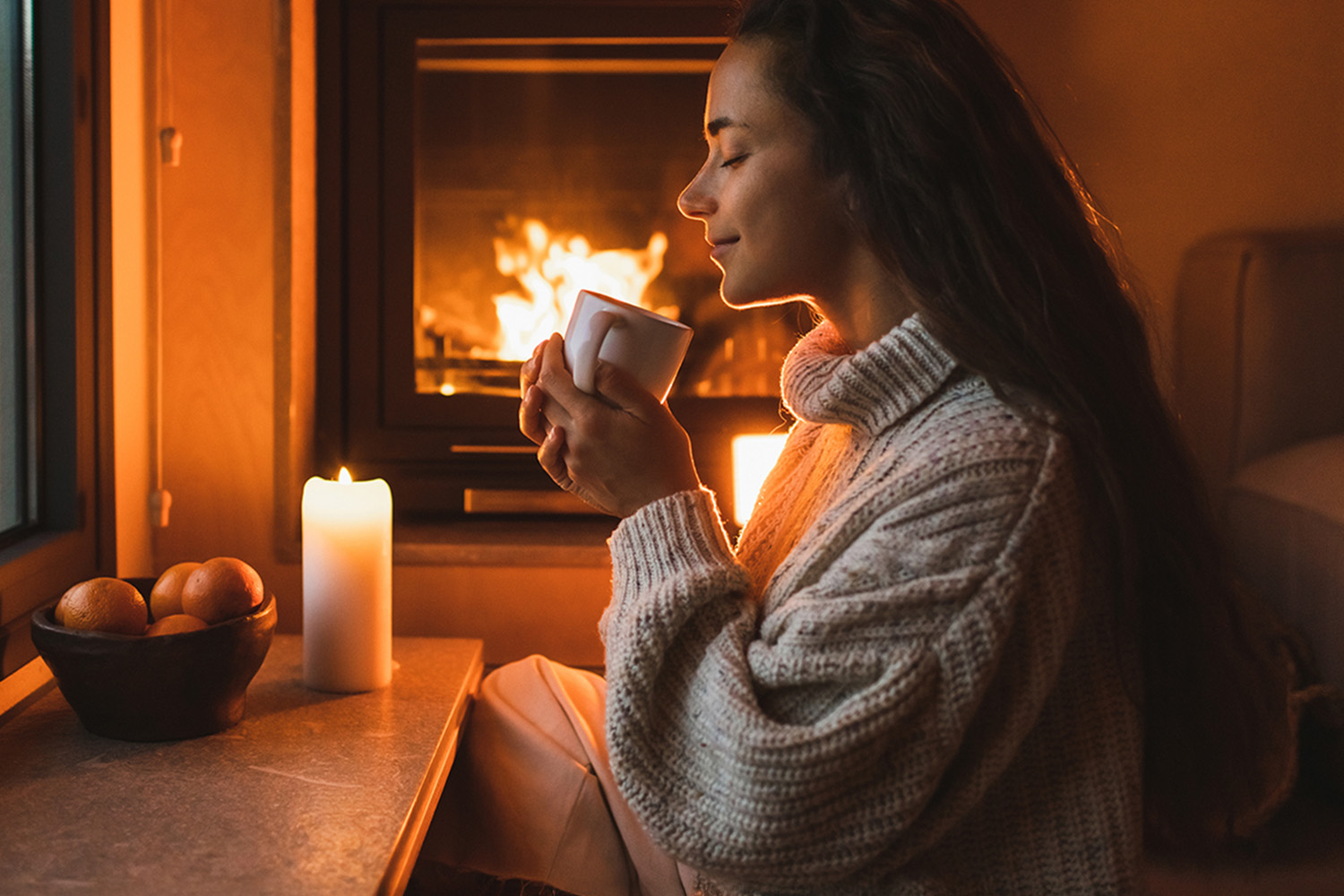 a woman drinking in front of a fire