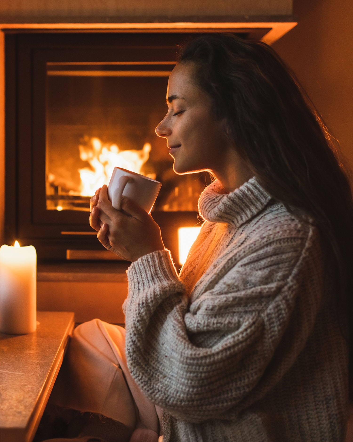 a woman drinking in front of a fire