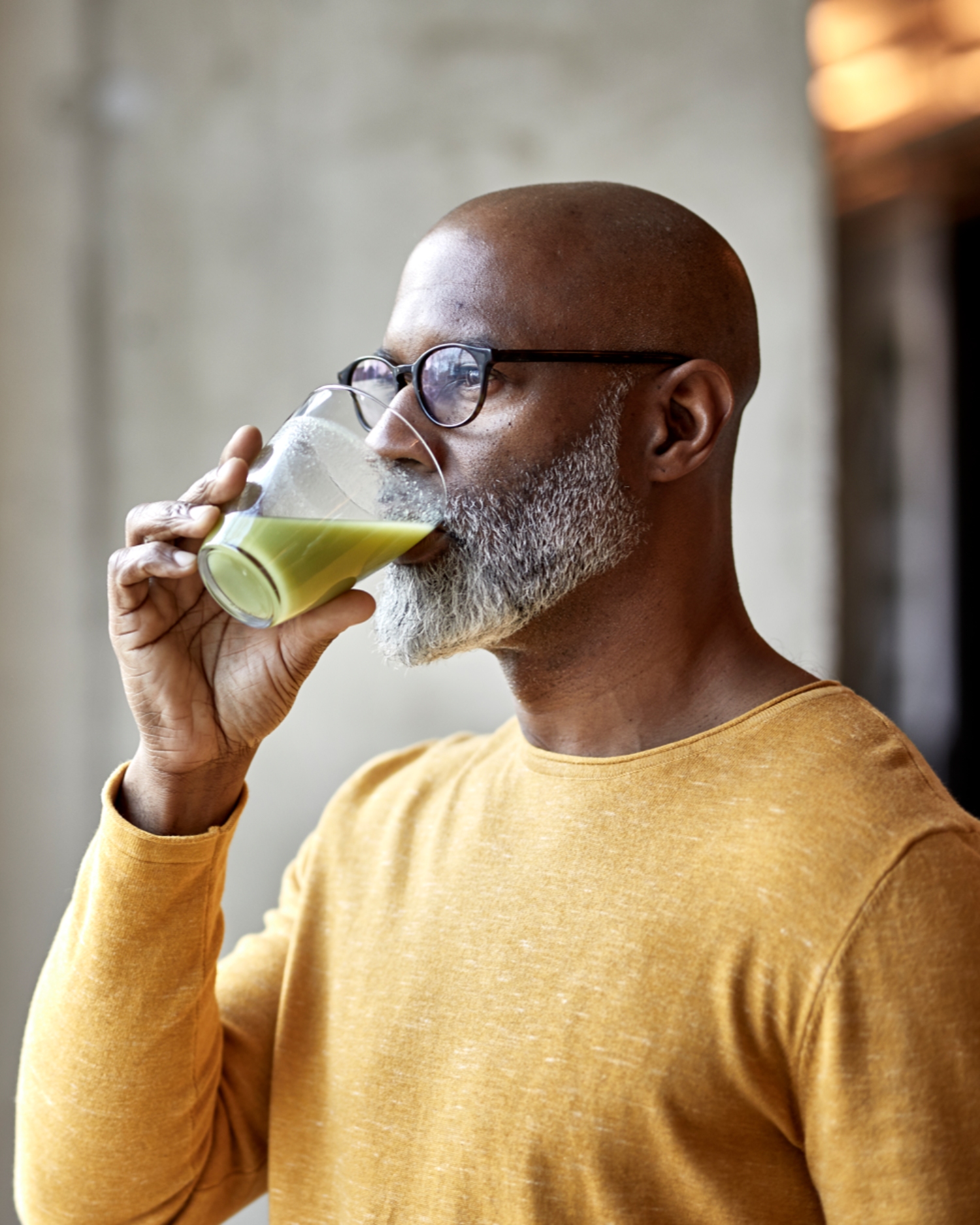 A man drinking a green smootie