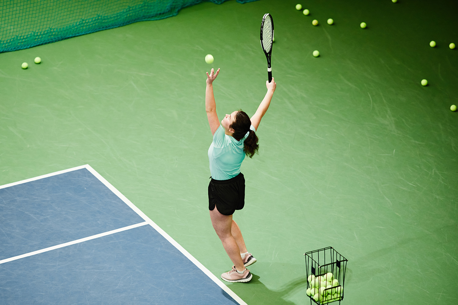 a woman serving a tennis ball