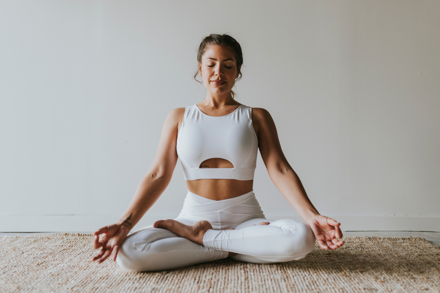 Girl doing meditation yoga in a white yoga suit