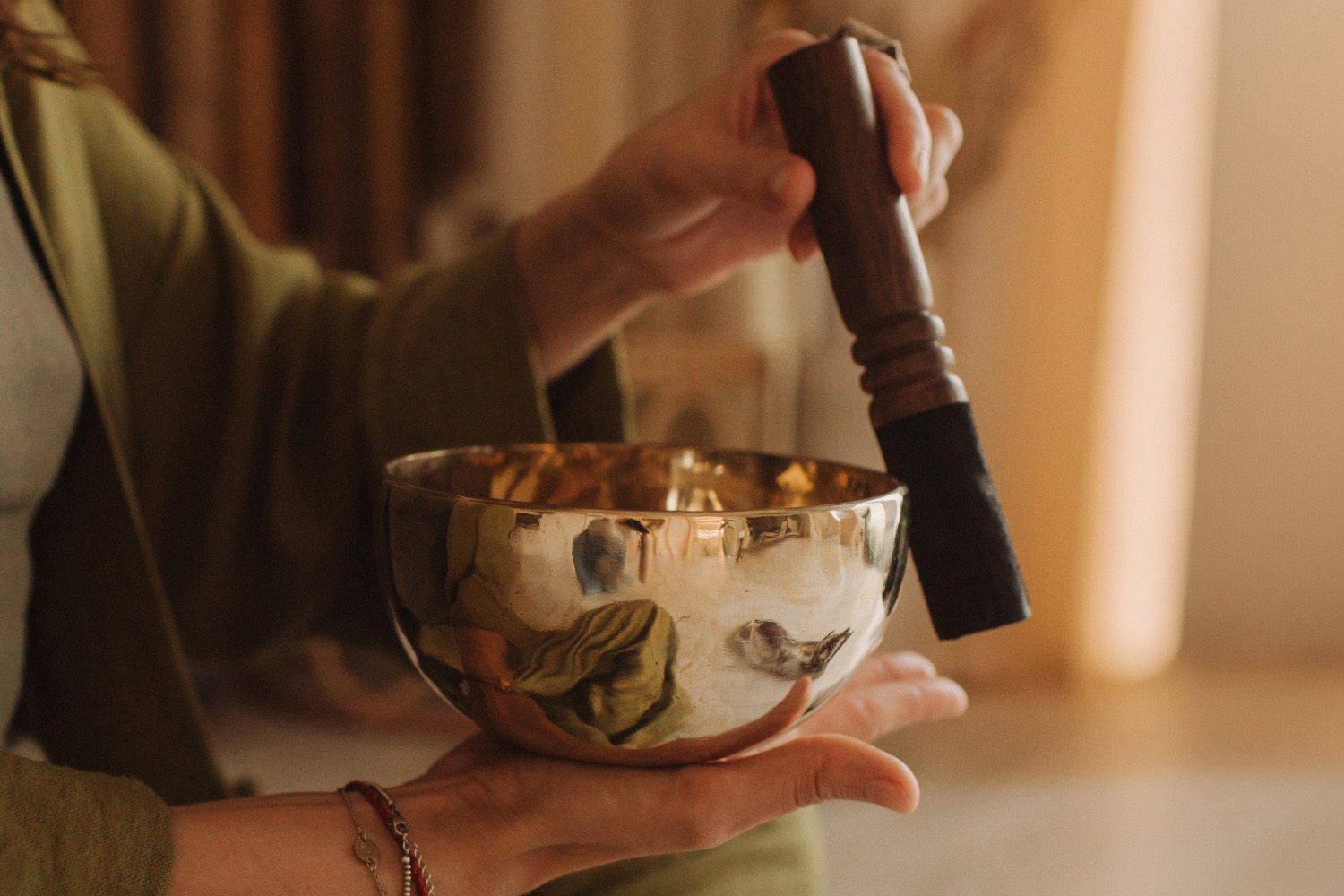 A sound healer with a brass singing bowl