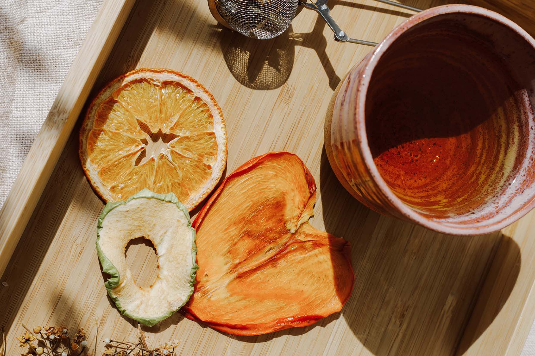 a display of dried fruits by a cup of tea