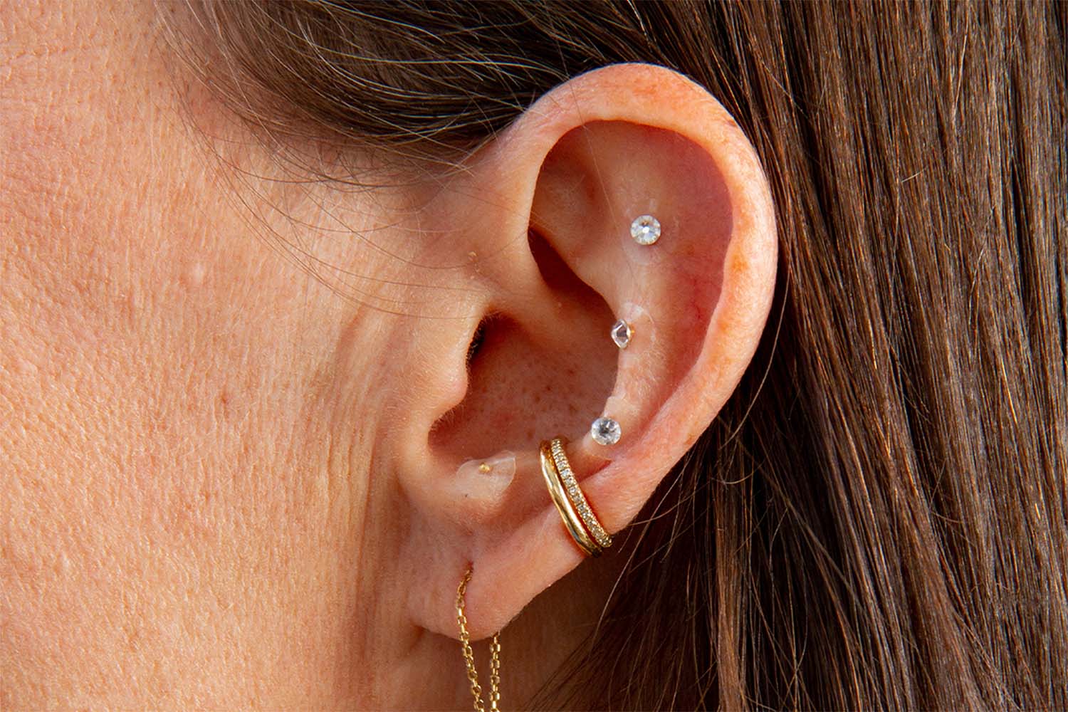 an ear with a variety of piercings