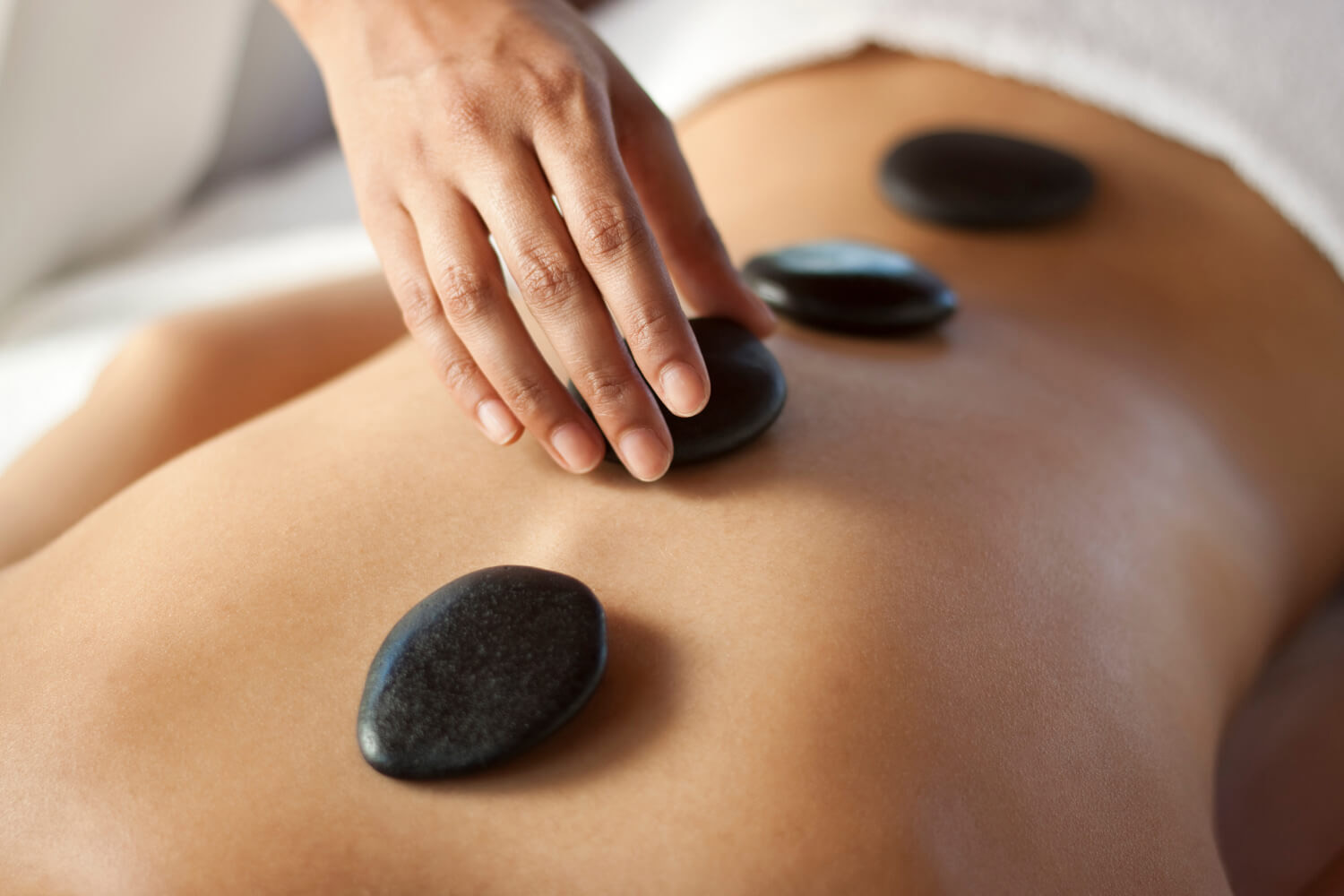 Woman getting a hot stone massage at Canyon Ranch Wellness Spa in Fort Worth