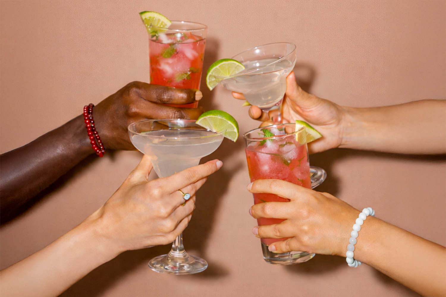 4 hands holding cocktails