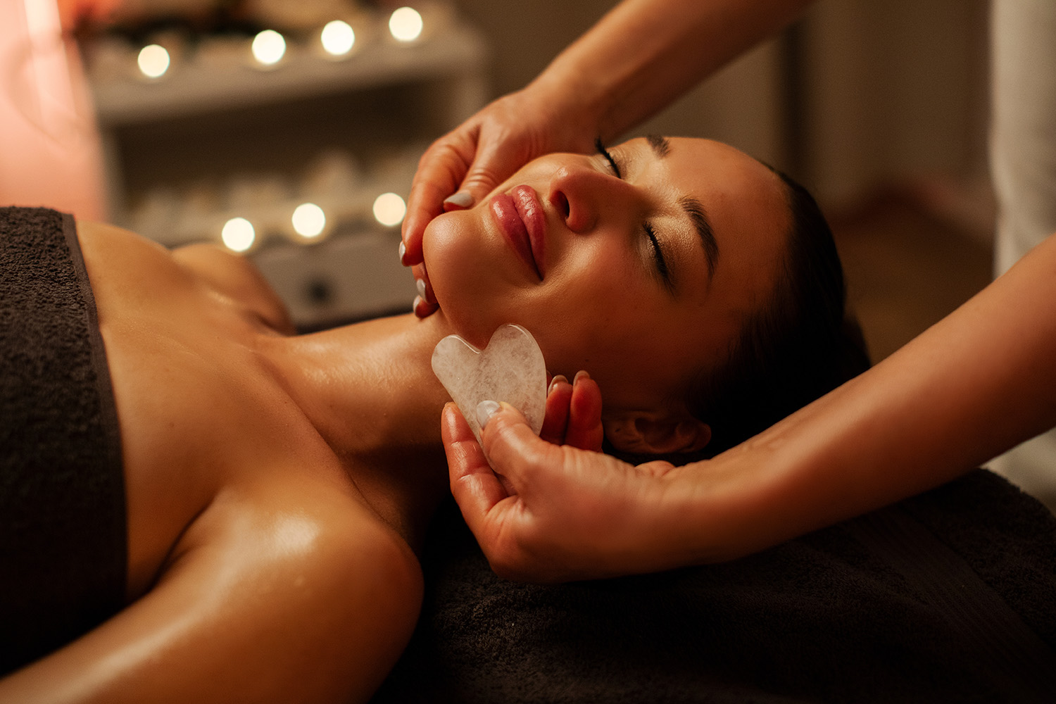 A woman getting Gua Sha on her face