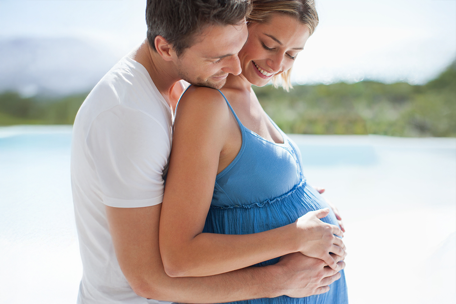 a pregnant woman being held by her partner