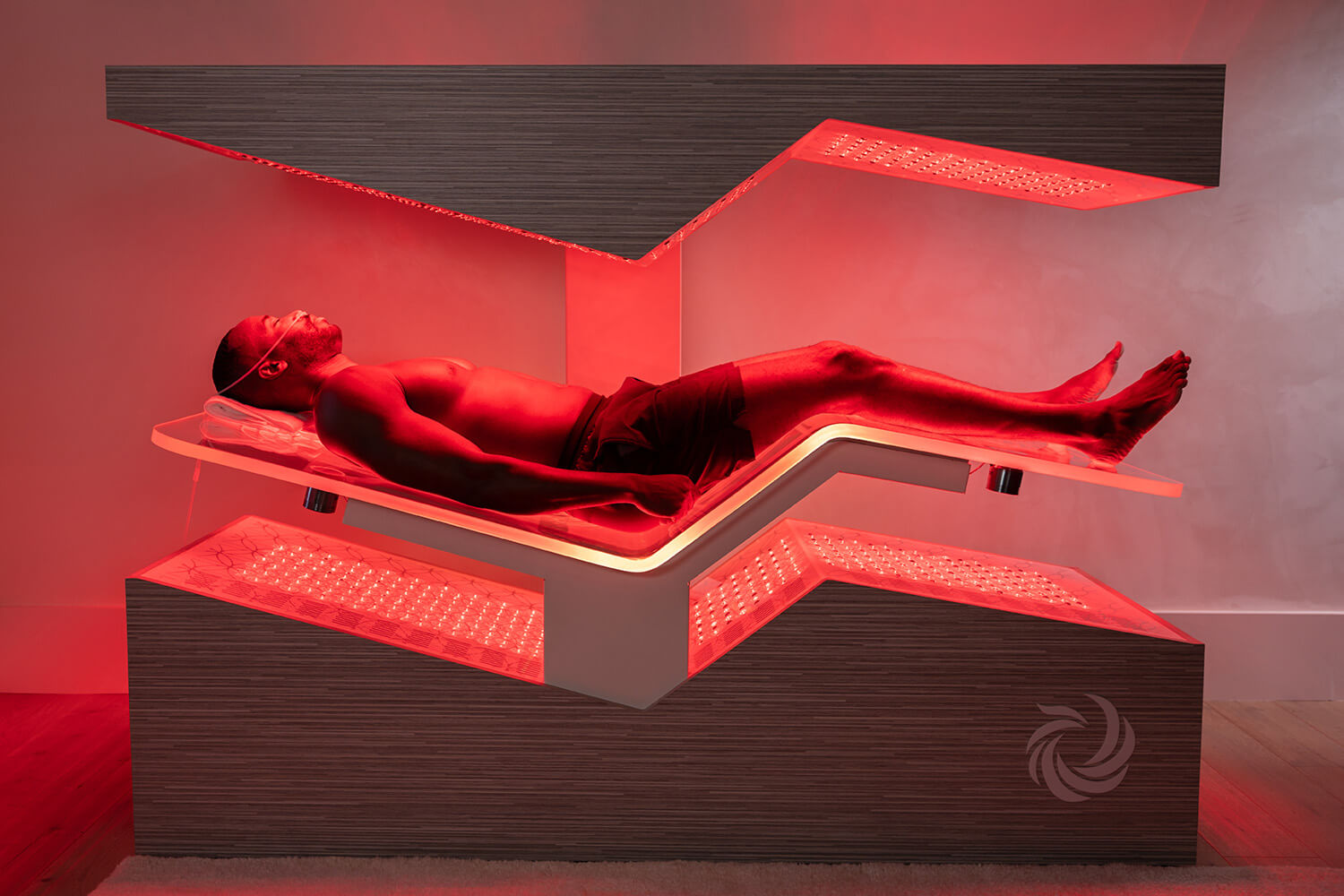 A man laying in a red light therapy bed
