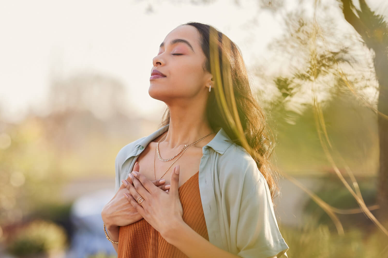 A woman breathing in deeply outdoors