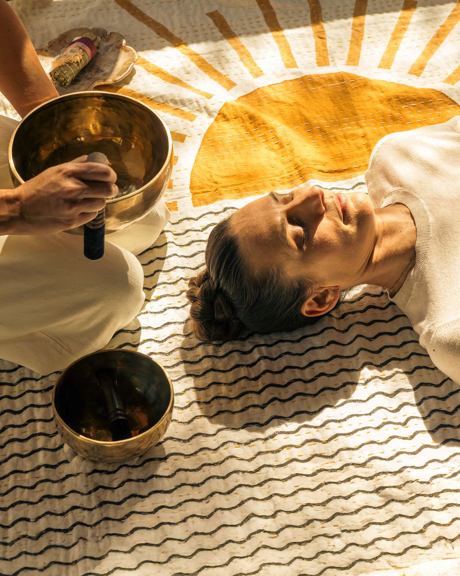 A woman getting a sound bath on a graphic blanket