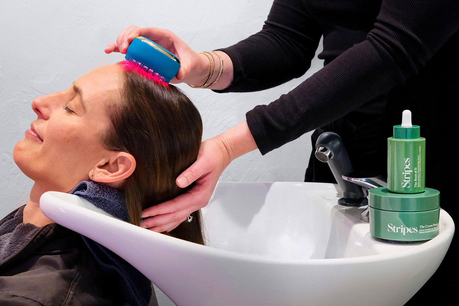a woman getting a hair treatment with stripes beauty products at canyon ranch