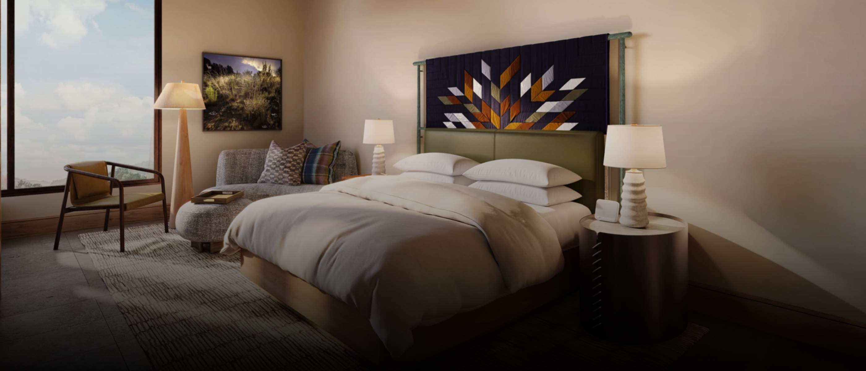A king room that has a white linen-covered bed in the center of the room, which looks out onto a balcony that is surrounded by trees.