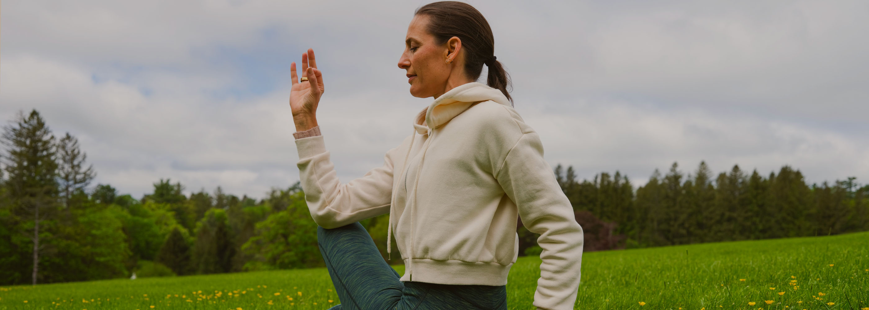 Woman Meditating and Practicing Yoga Outdoors in the Grass