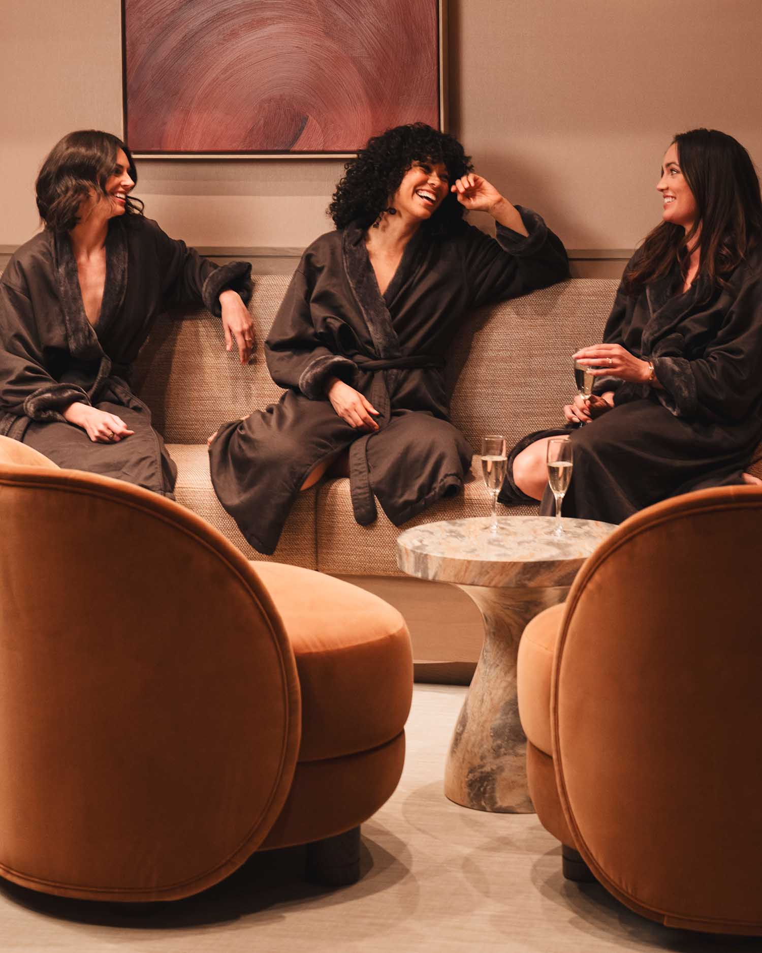 Two girlfriends in robes a the spa laughing with each other