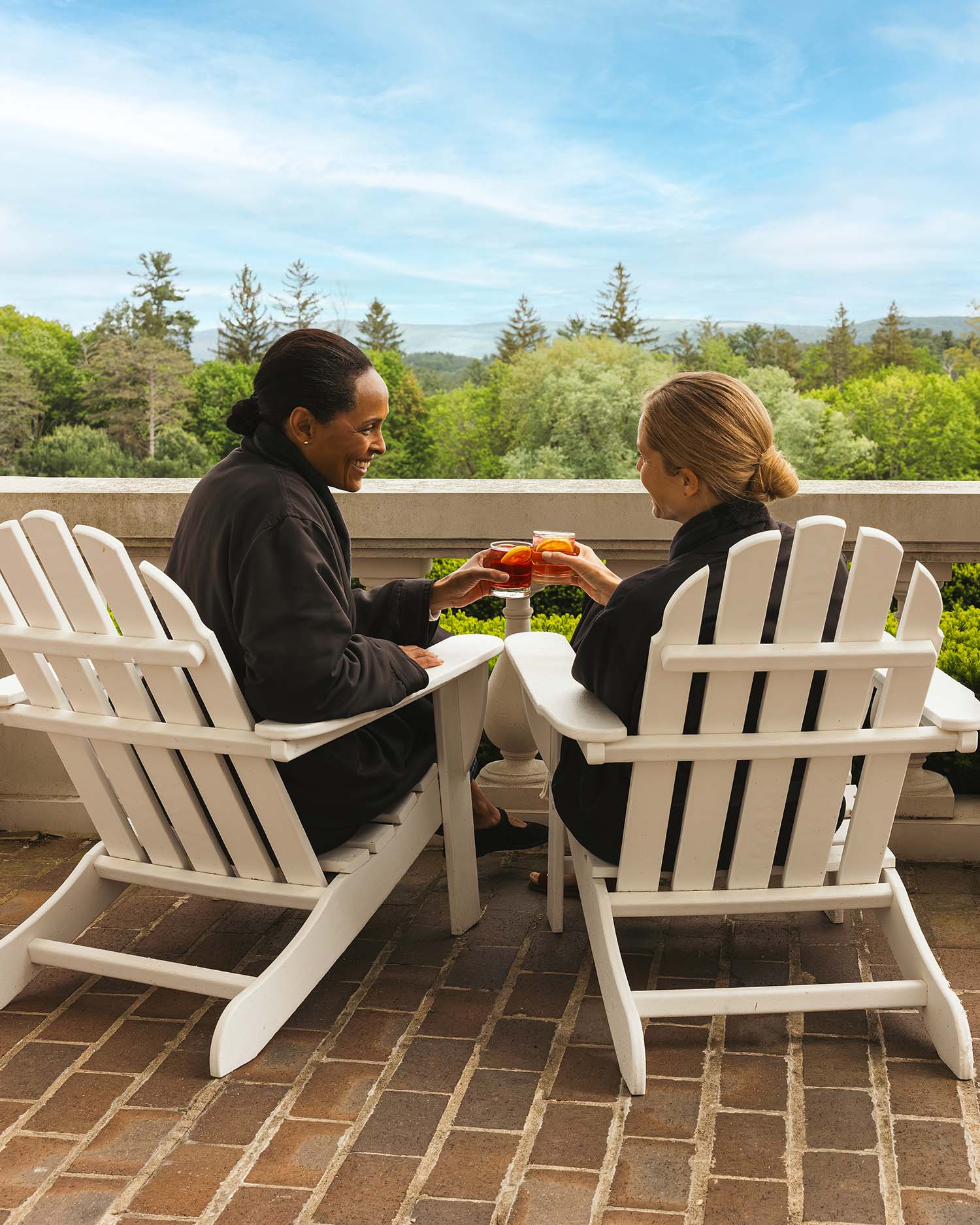 Two women drinking mocktails on the great lawn at canyon ranch lenox