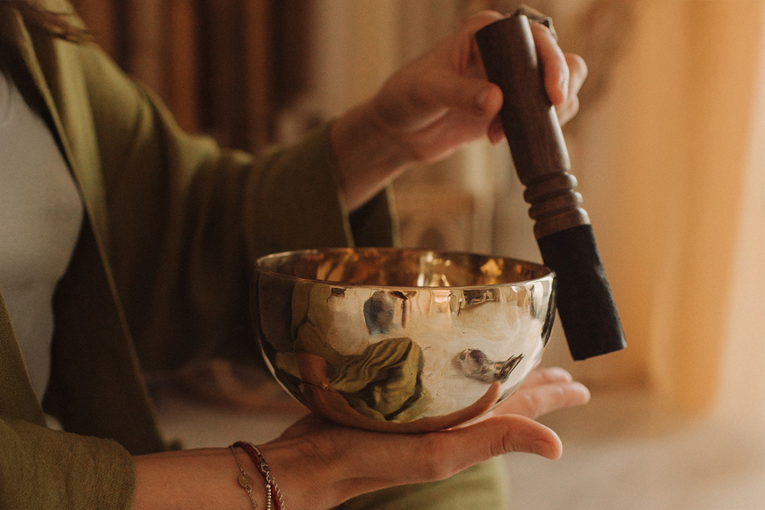 a woman holding a sound bowl