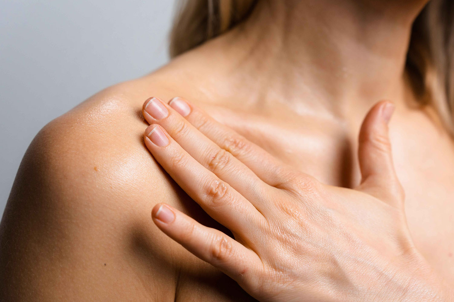A woman with her hand on her shoulder