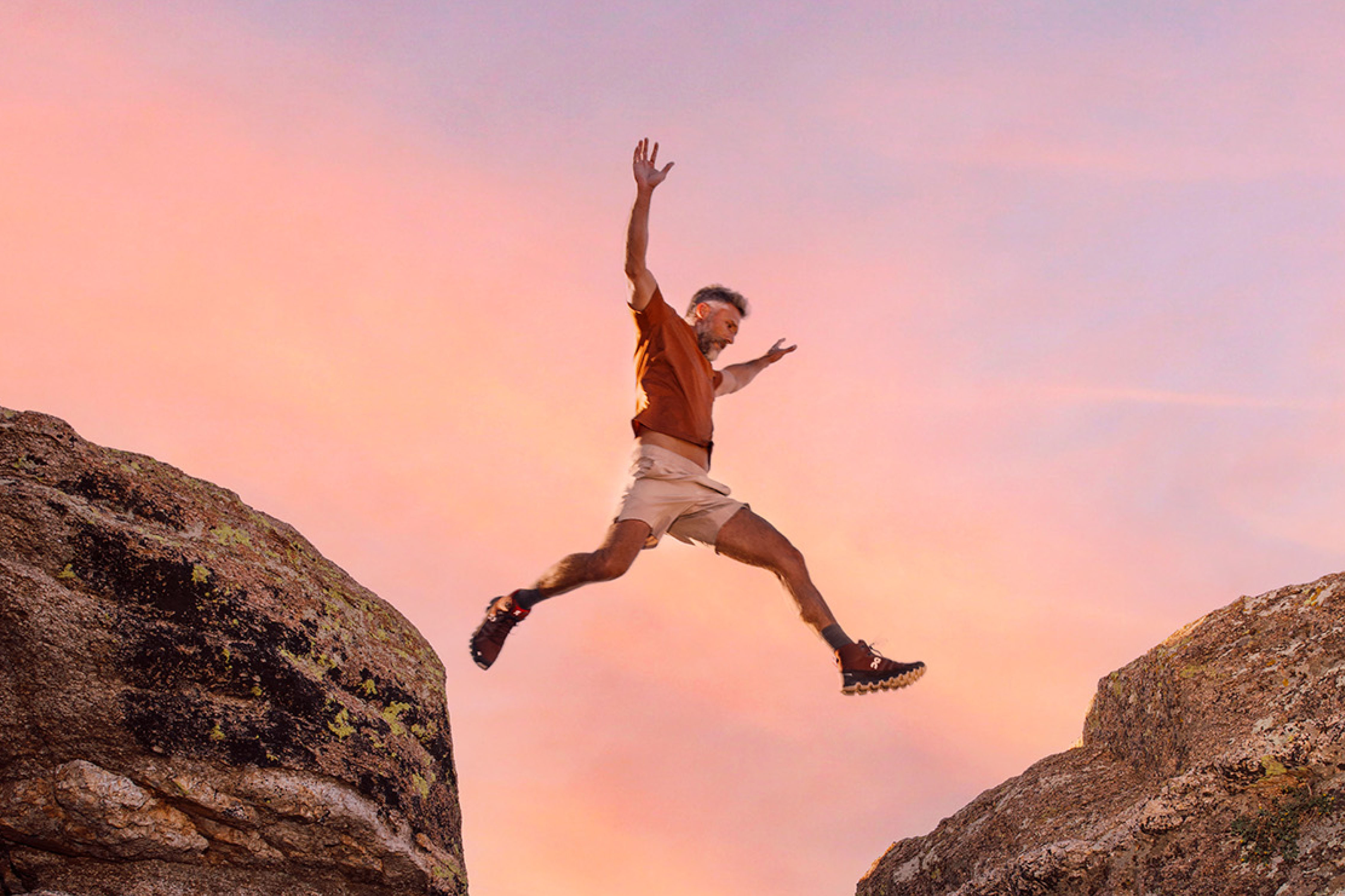 a man jumping over boulders on the Catalina Mountains