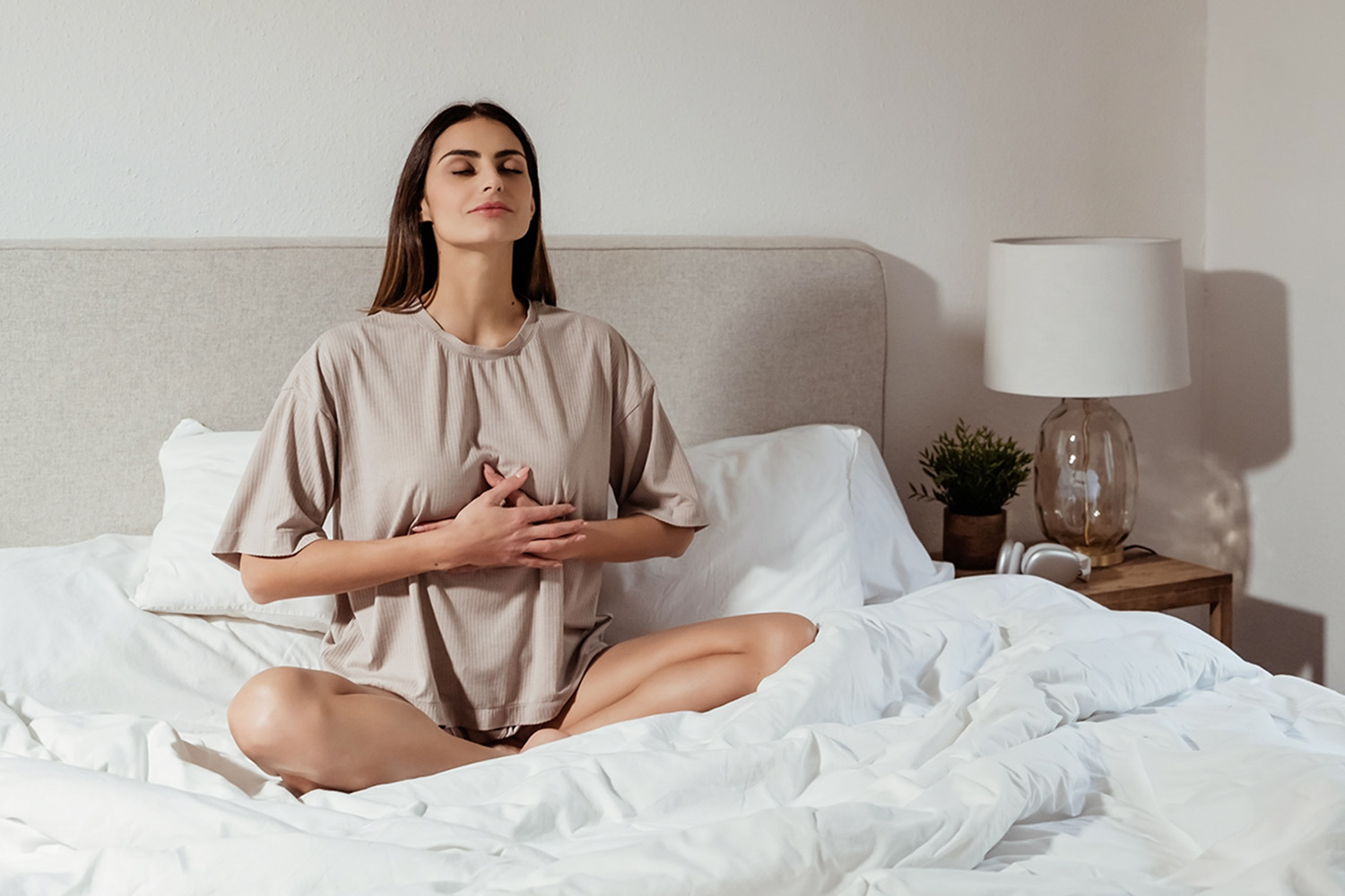 a woman meditating in her bed