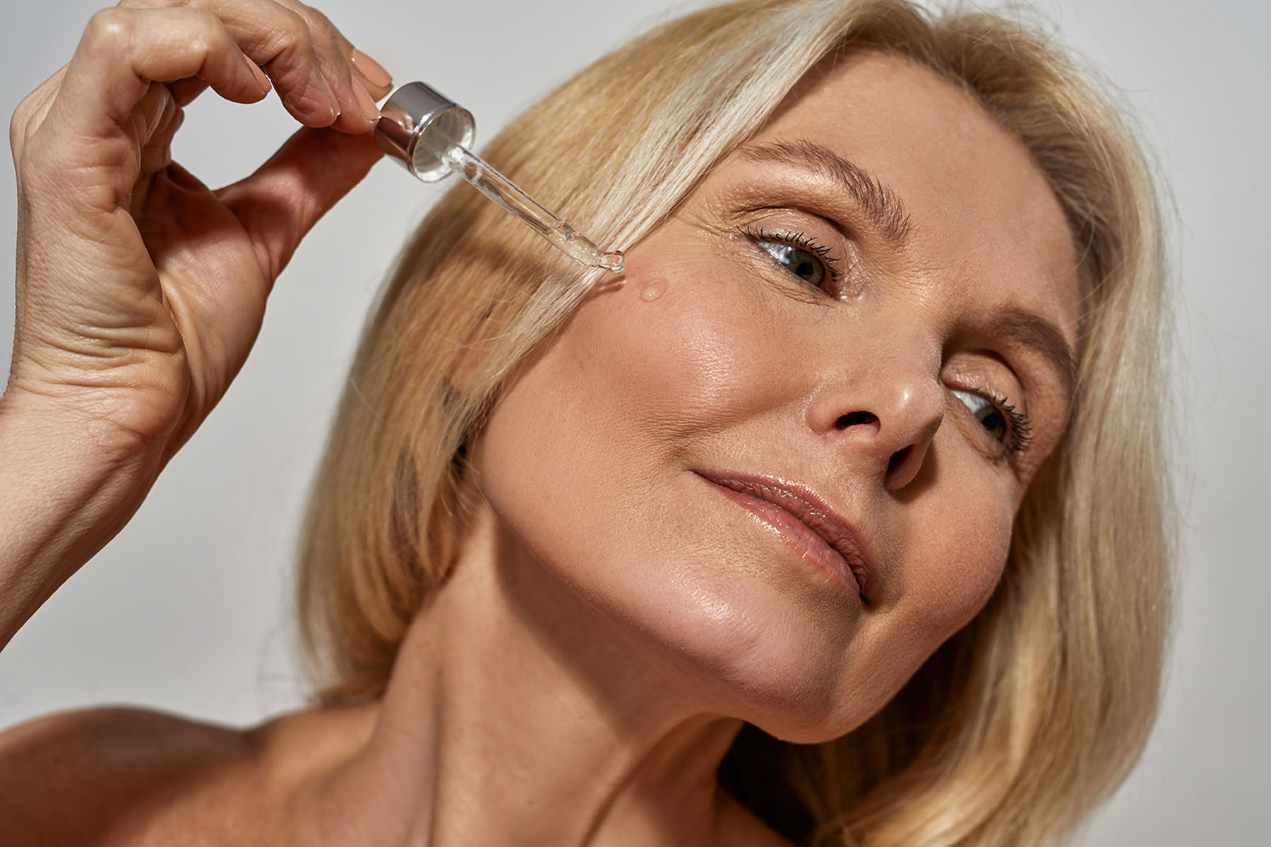 a woman putting skin care products on her face