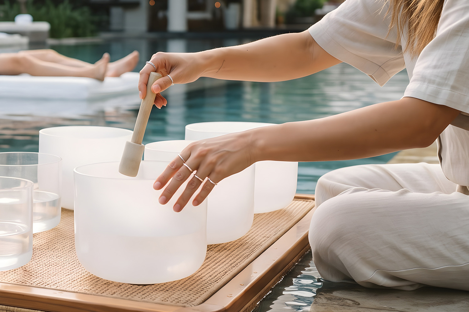 a woman playing with sound bowls