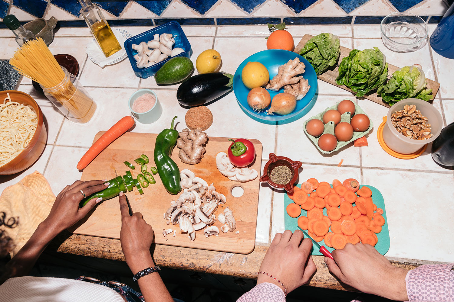 A Table Full of Food With People Cooking a Meal 