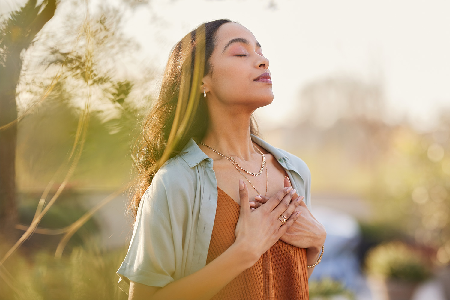 Woman Meditating Outside With Both Hands Over Her Heart