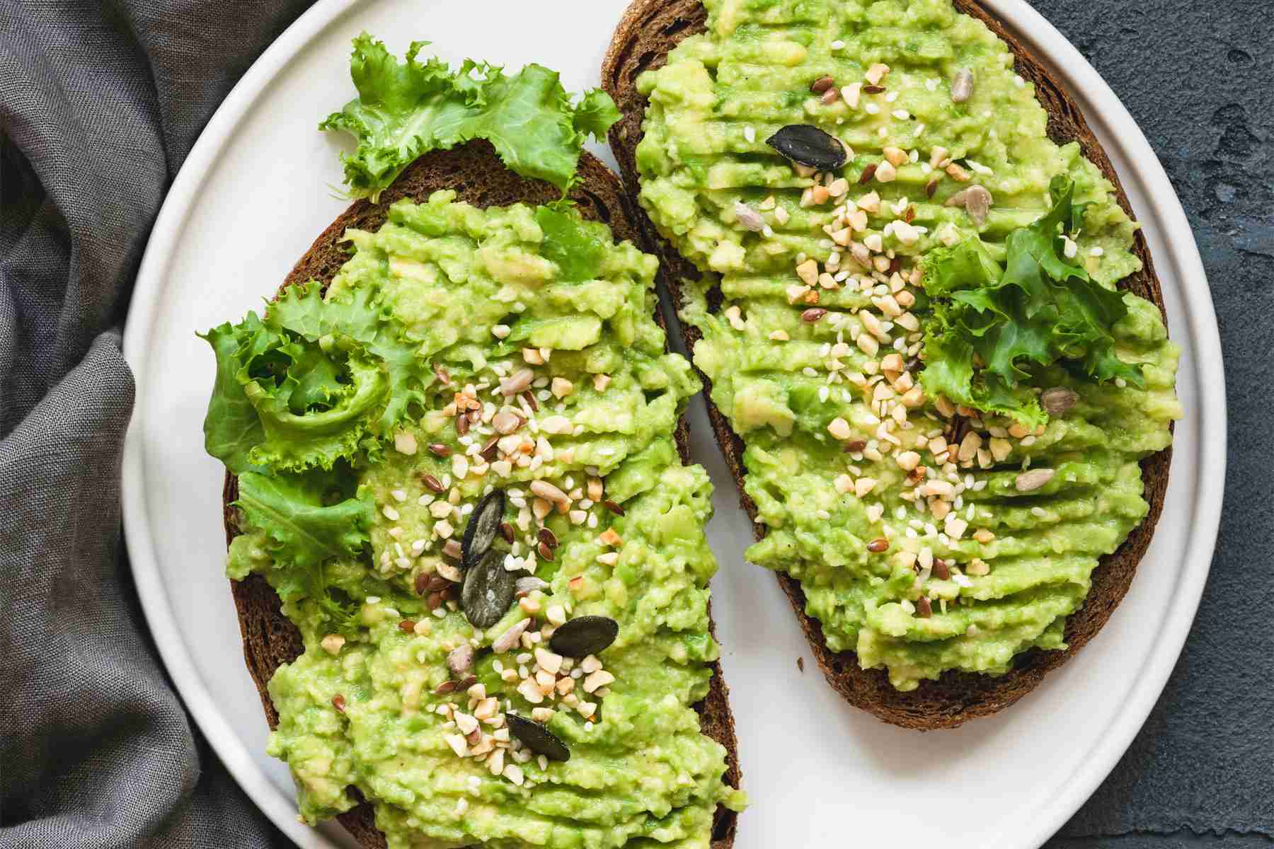 Avocado toast on a white plate shot from overhead.