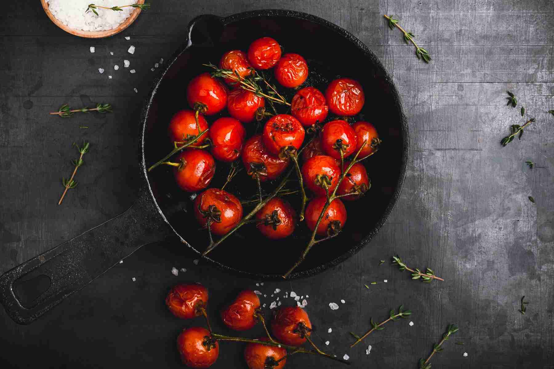 Cast iron pan filled with roasted tomatoes.