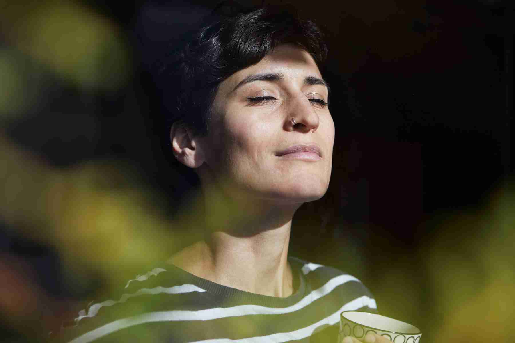 A close-up of a woman breathing in the fresh air.