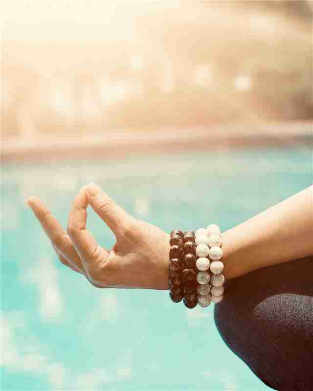 a woman meditating by the pool