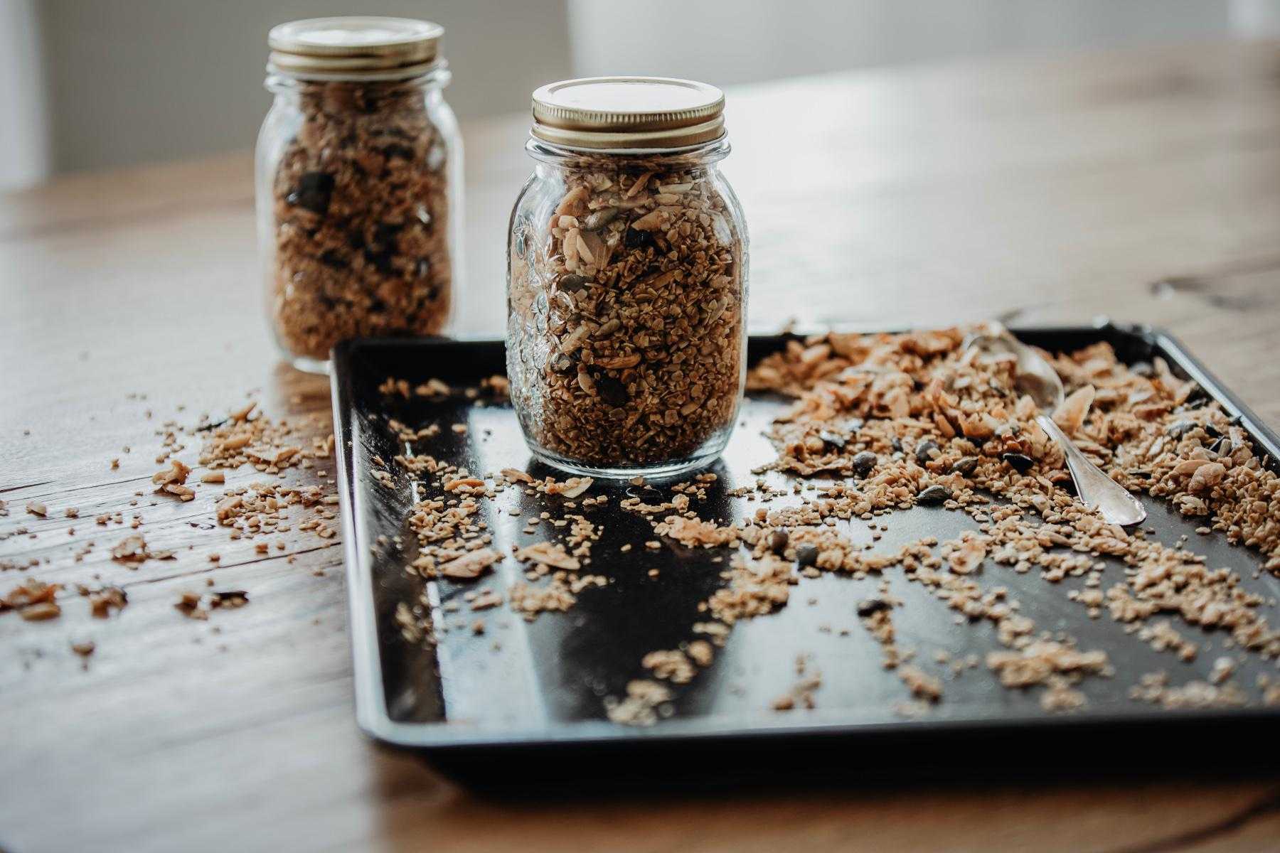 Metal baking tray with granola scattered on it.