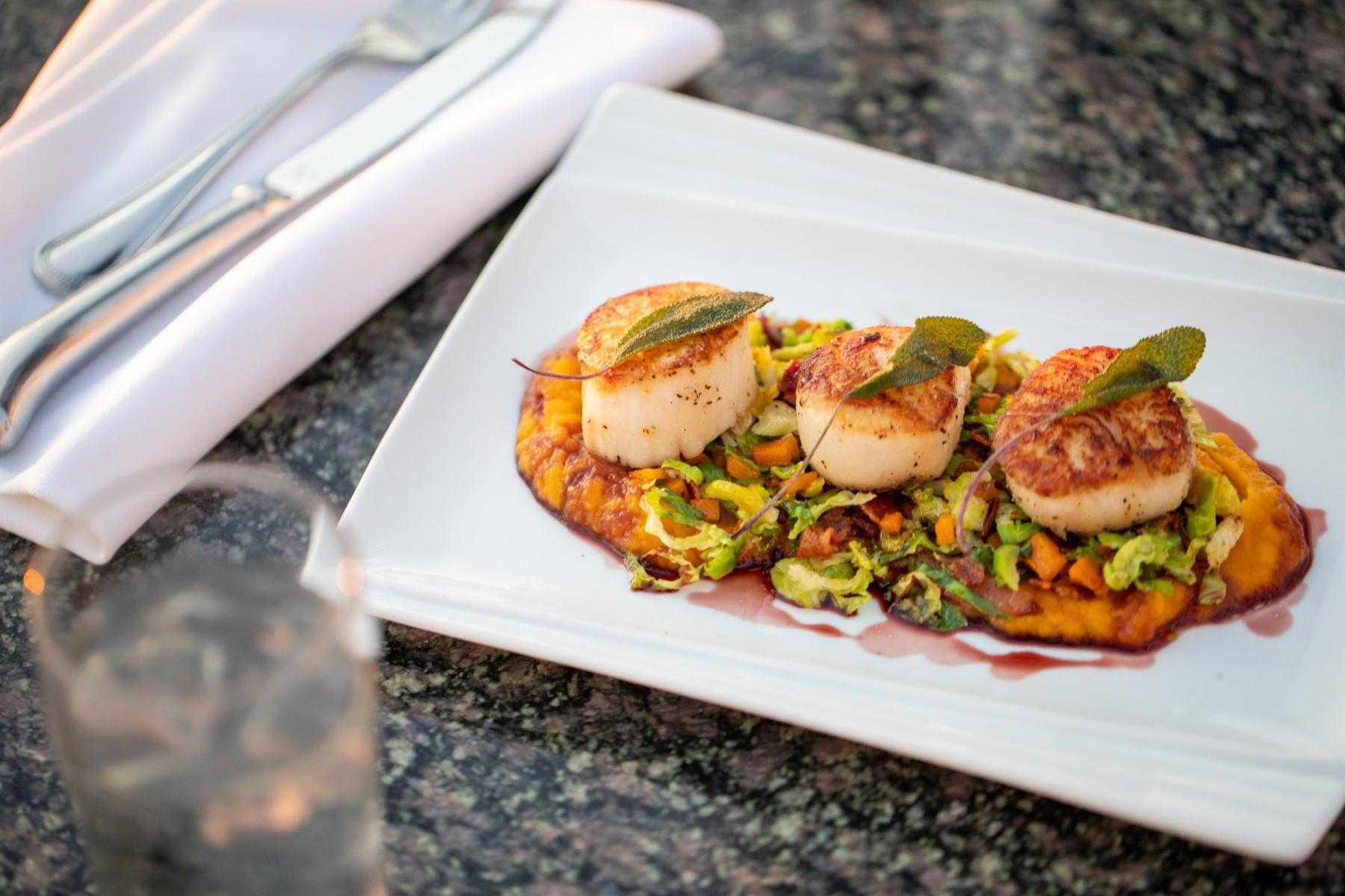 Jamaican scallops on square white plate.