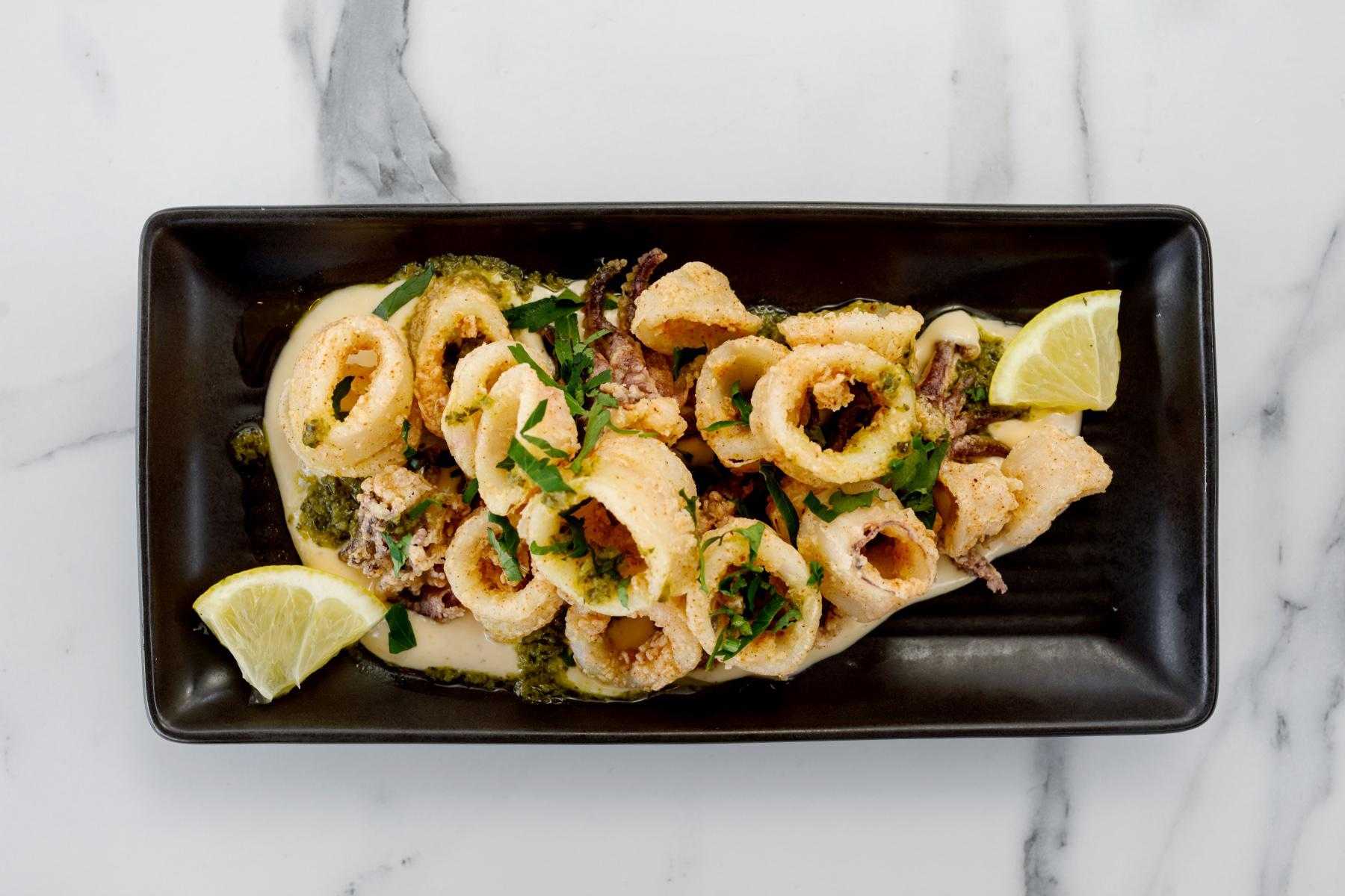 Overhead view of a black plate covered with calamari.