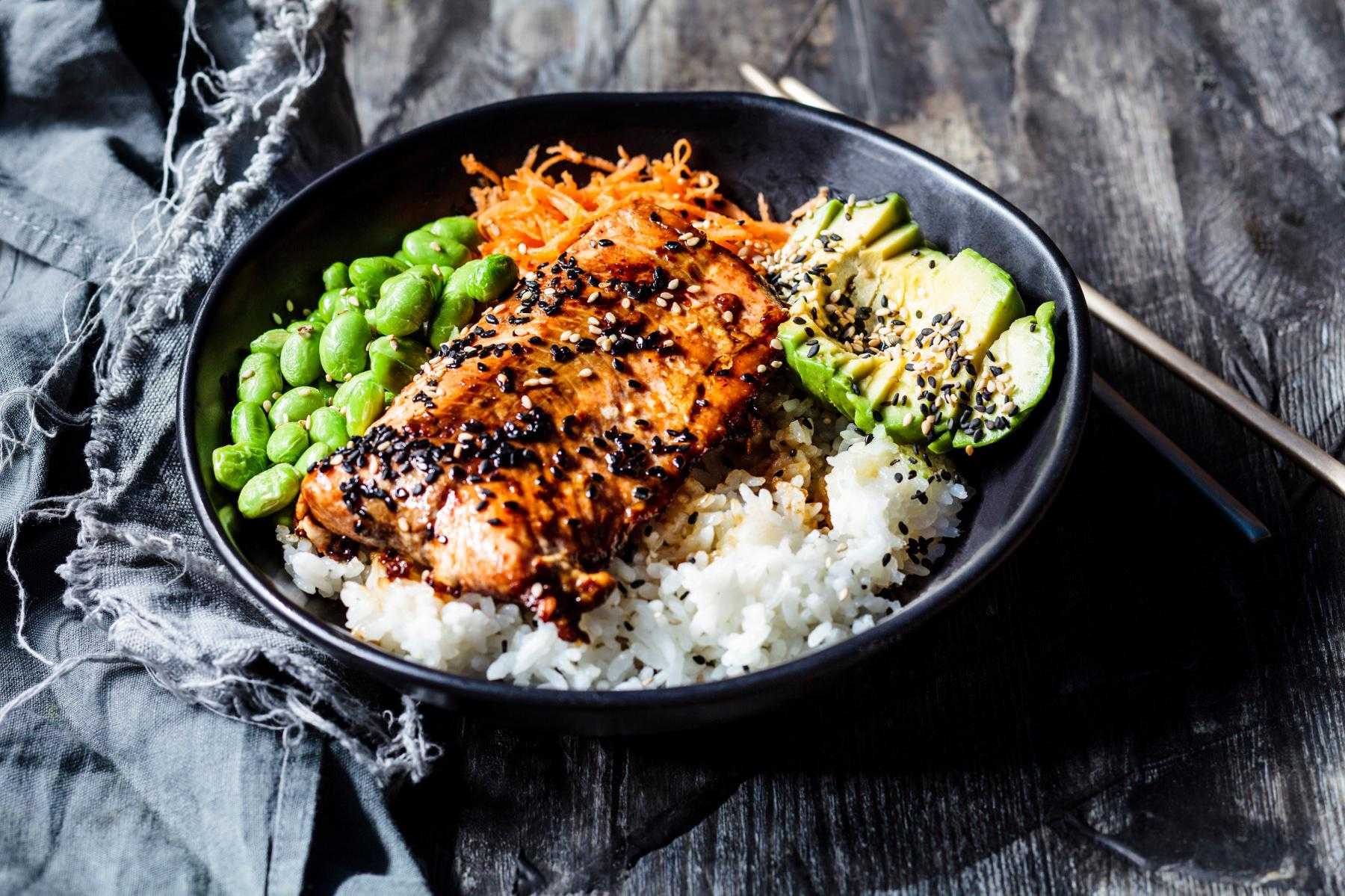 A bowl of sesame-crusted salmon and sesame orange sauce.