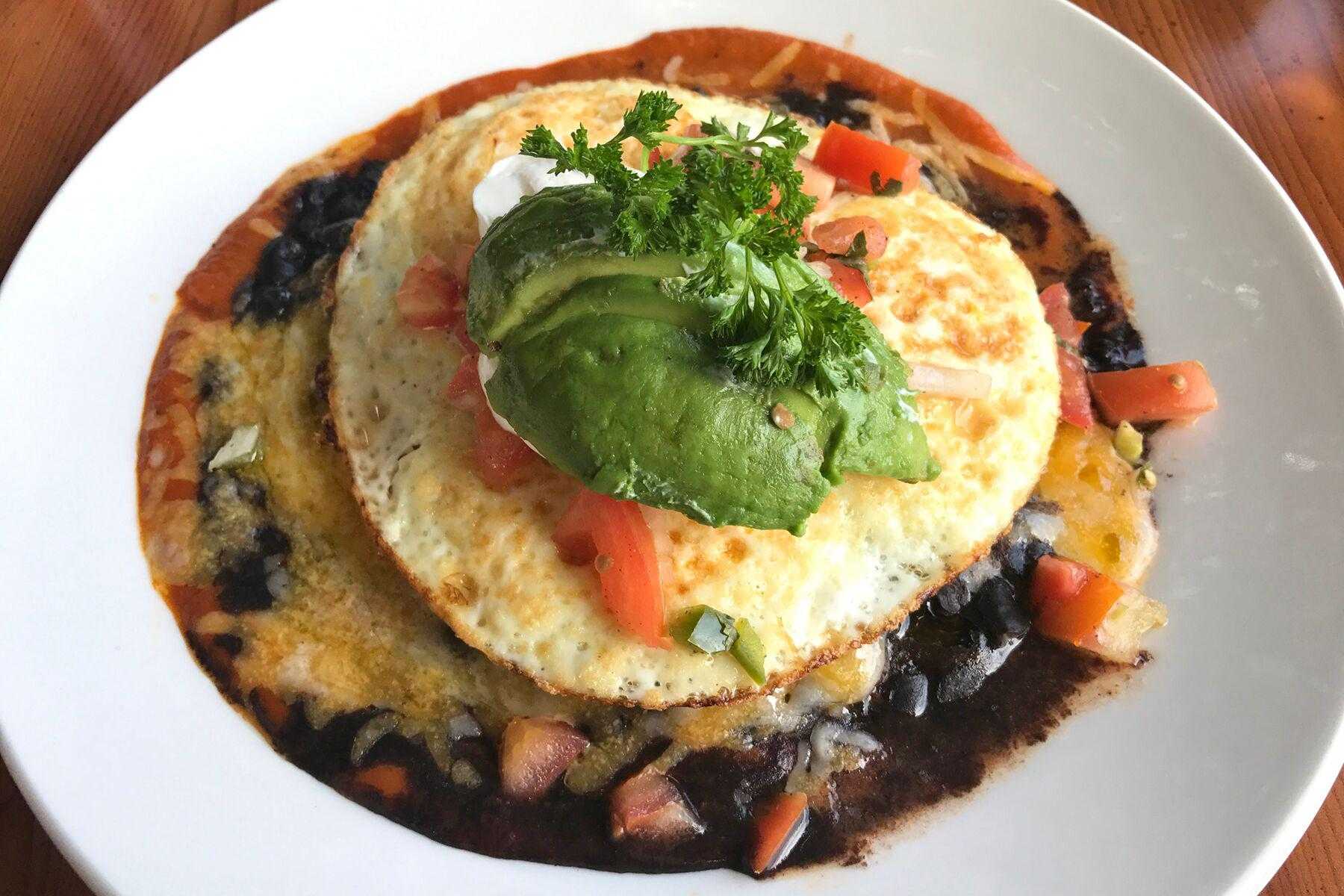 Red salsa chilaquiles on a white plate
