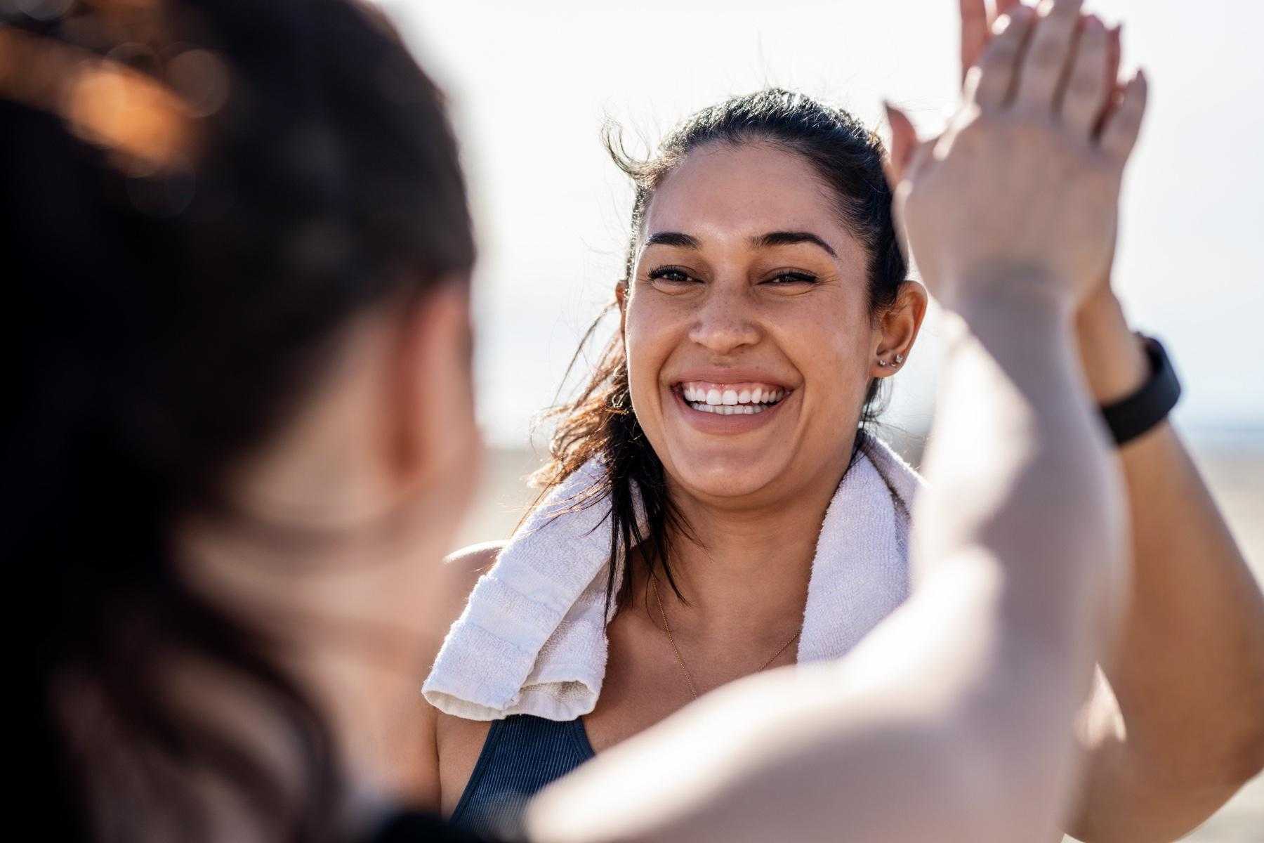 close-up of woman outside high-fiving another woman