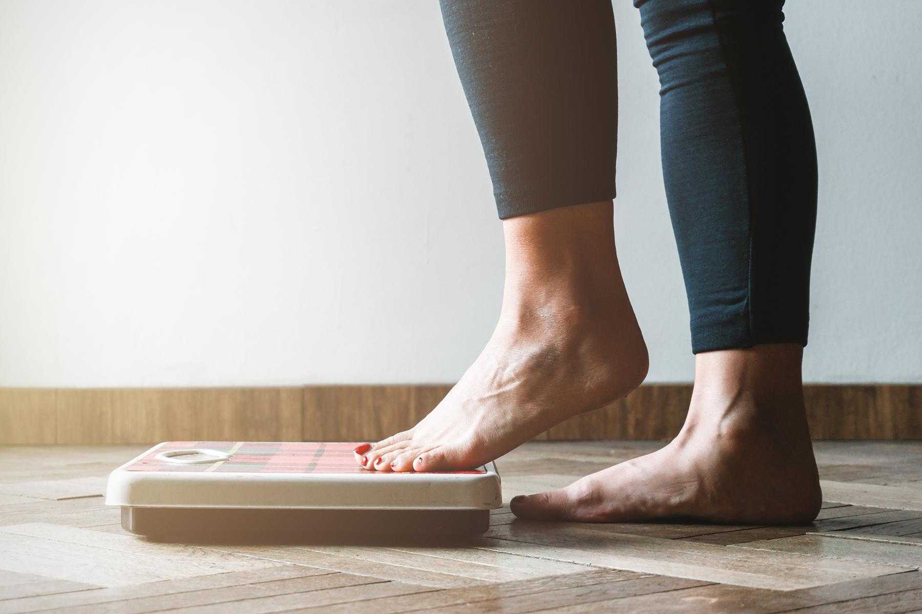 Feet stepping on to a scale.