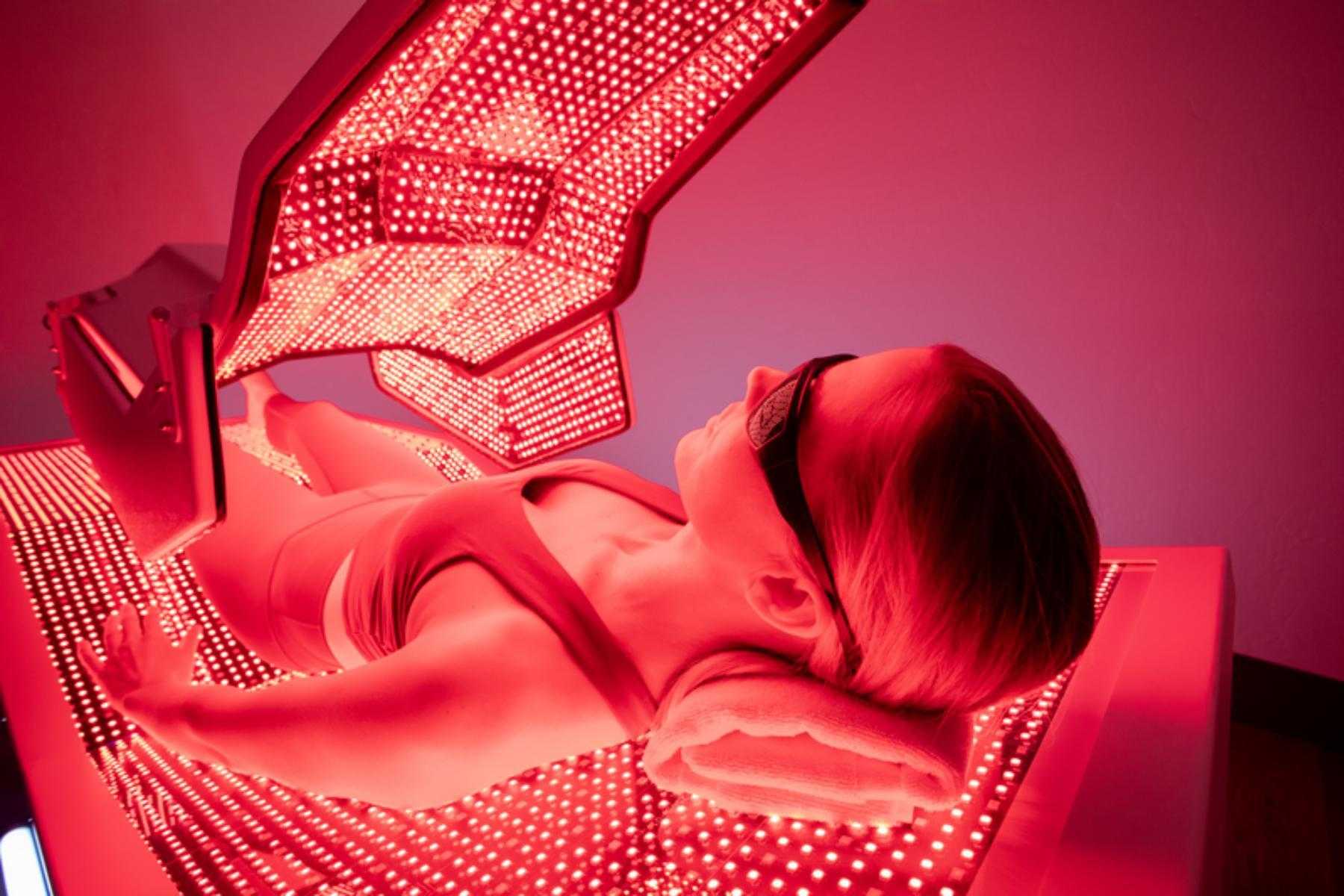 A woman in the red light therapy bed at CR Vitality