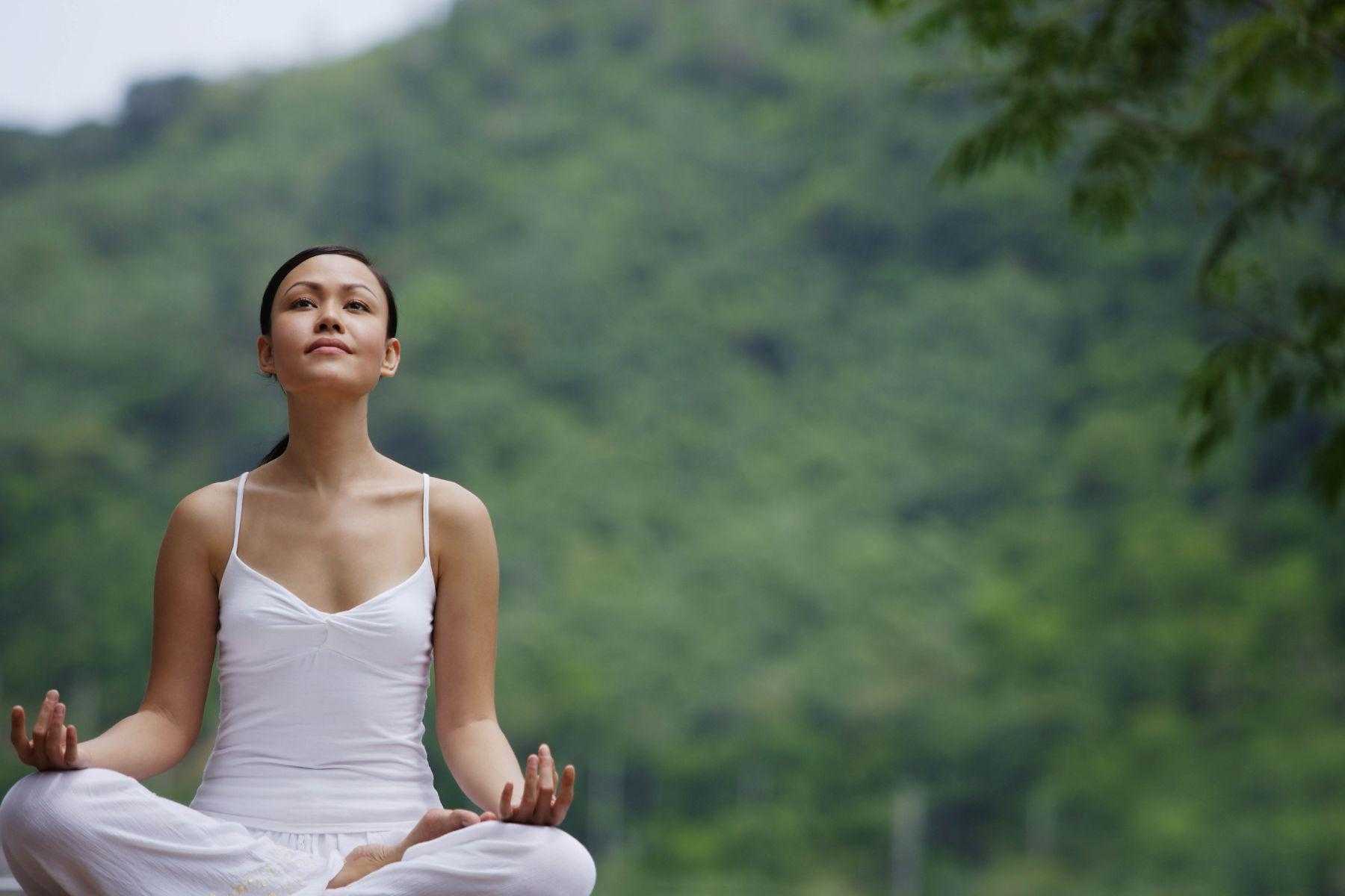 Woman meditating outside.