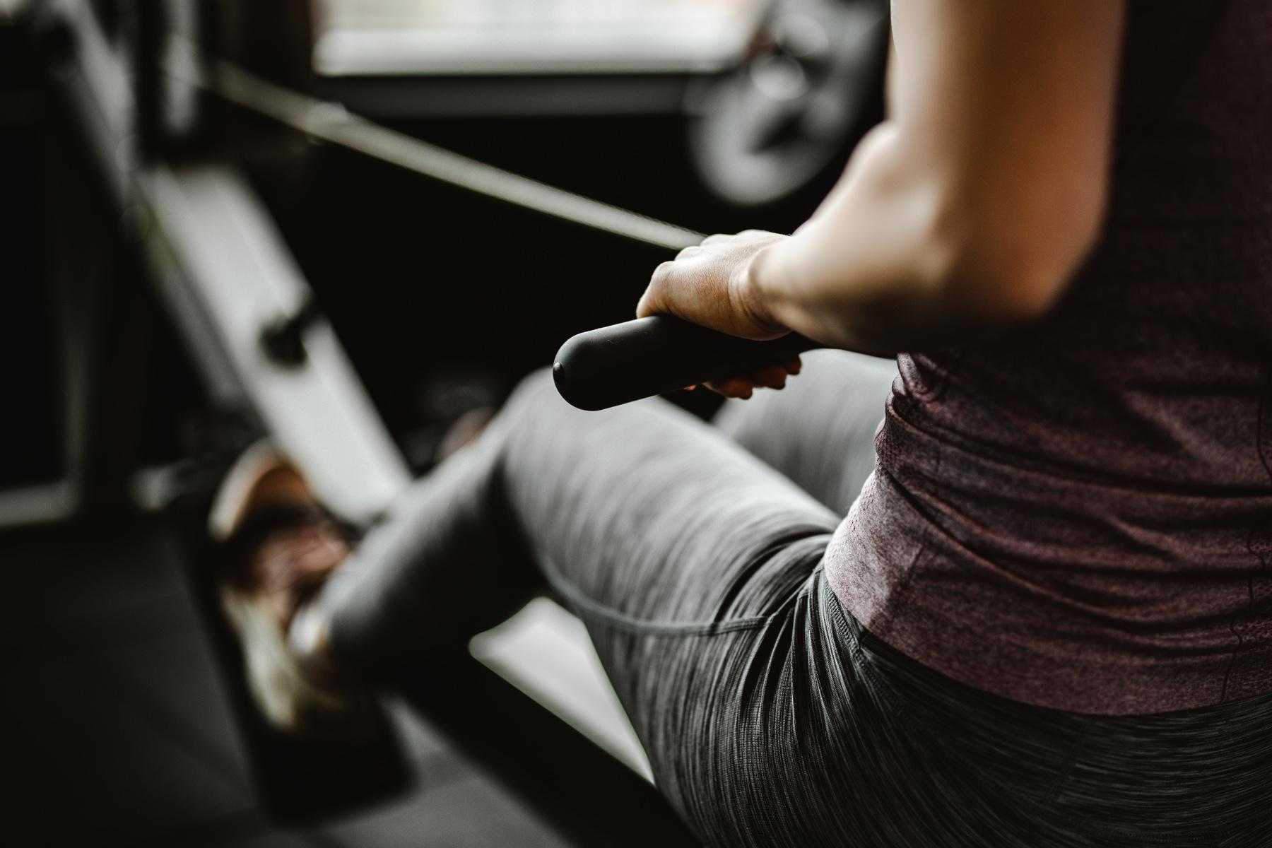 close up of woman mid-workout on rowing machine