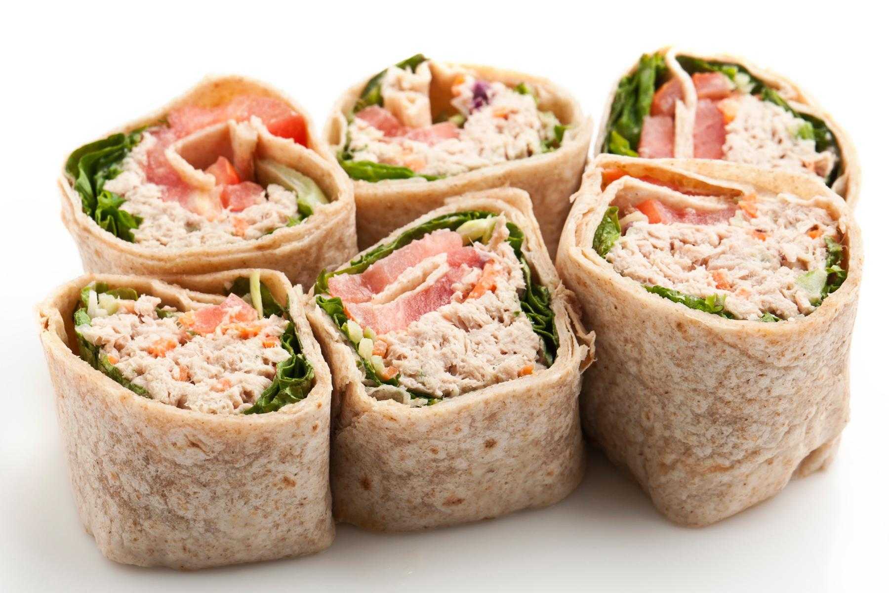 Overhead view of tuna salad wraps cut in half.