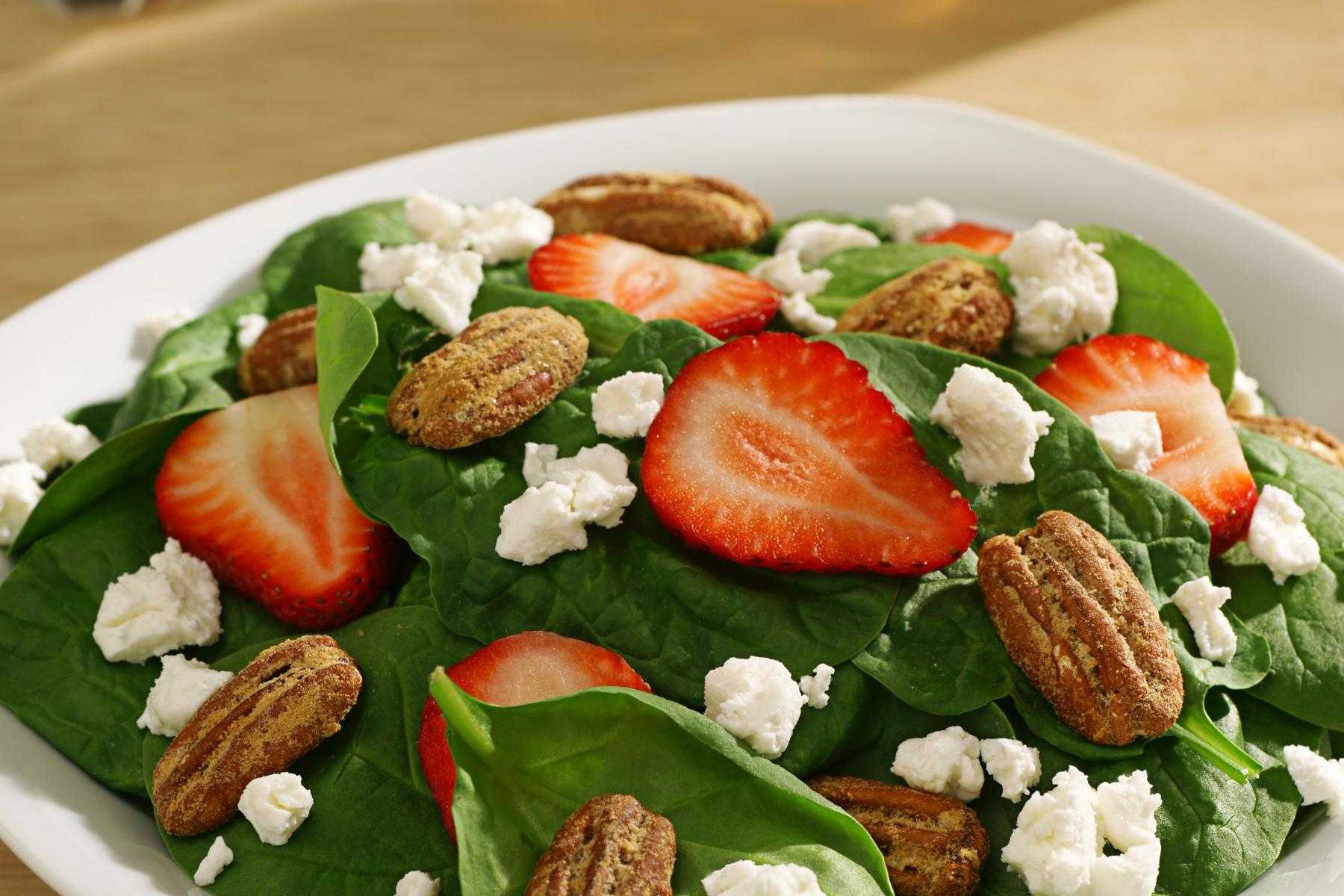 Overhead view of a bowl of spinach salad with strawberry champagne vinaigrette.
