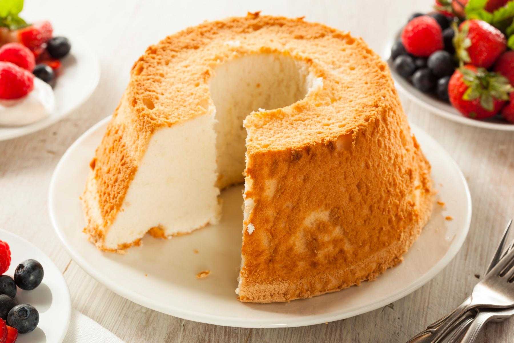 Angel food cake with slice out of it.