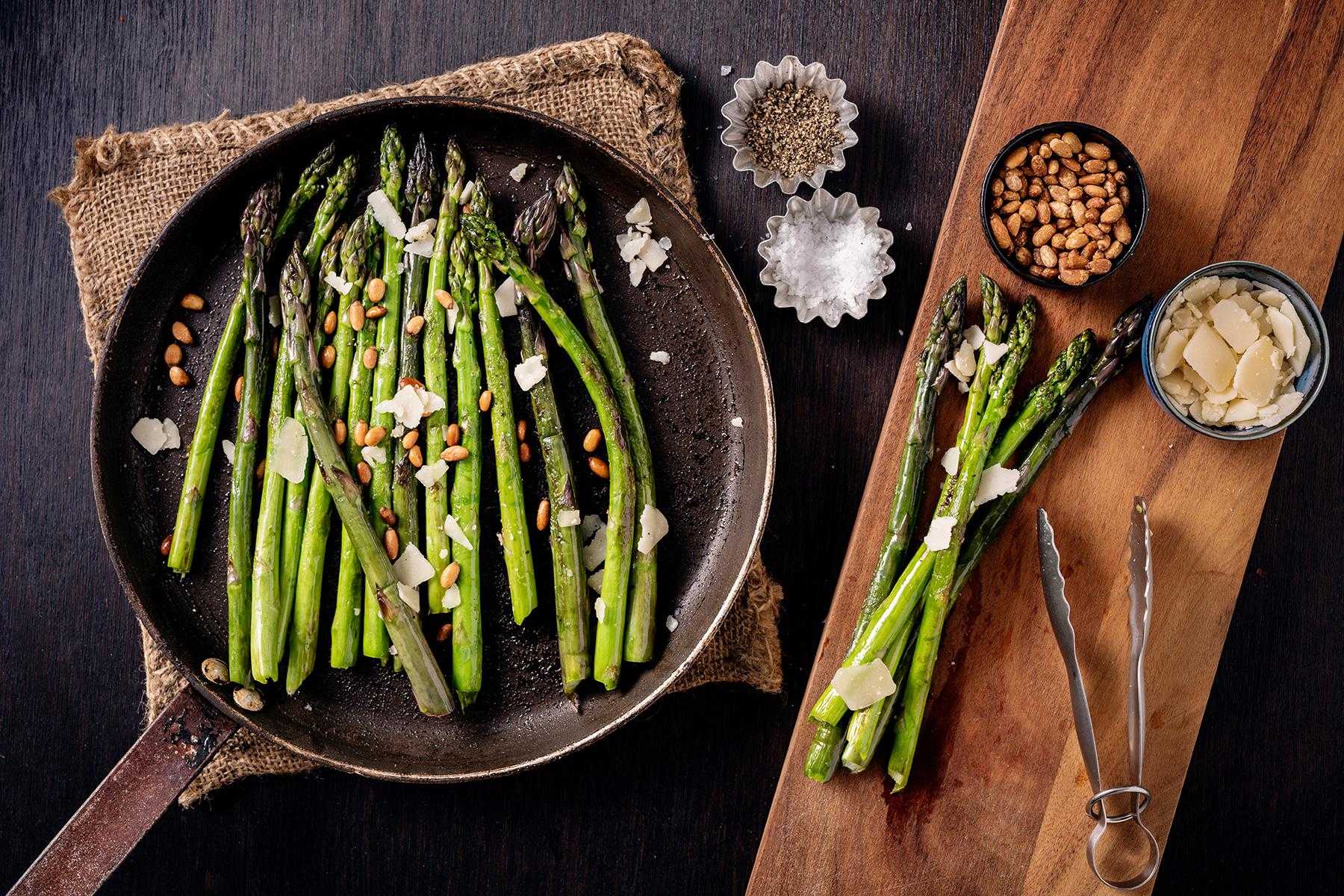 Asparagus cooking in a cast iron pan.