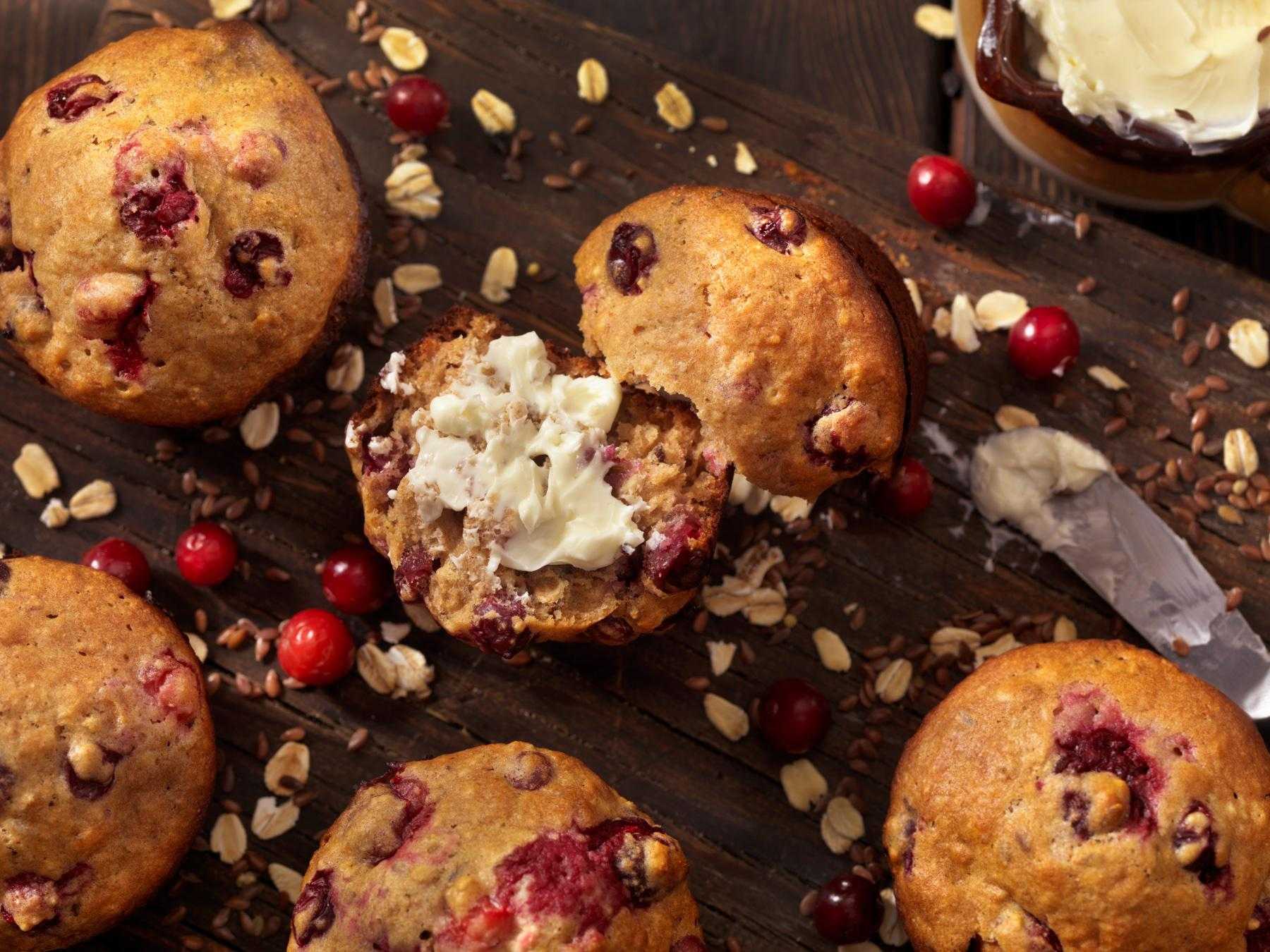 Overhead view of fruit muffins are dark wooden table.