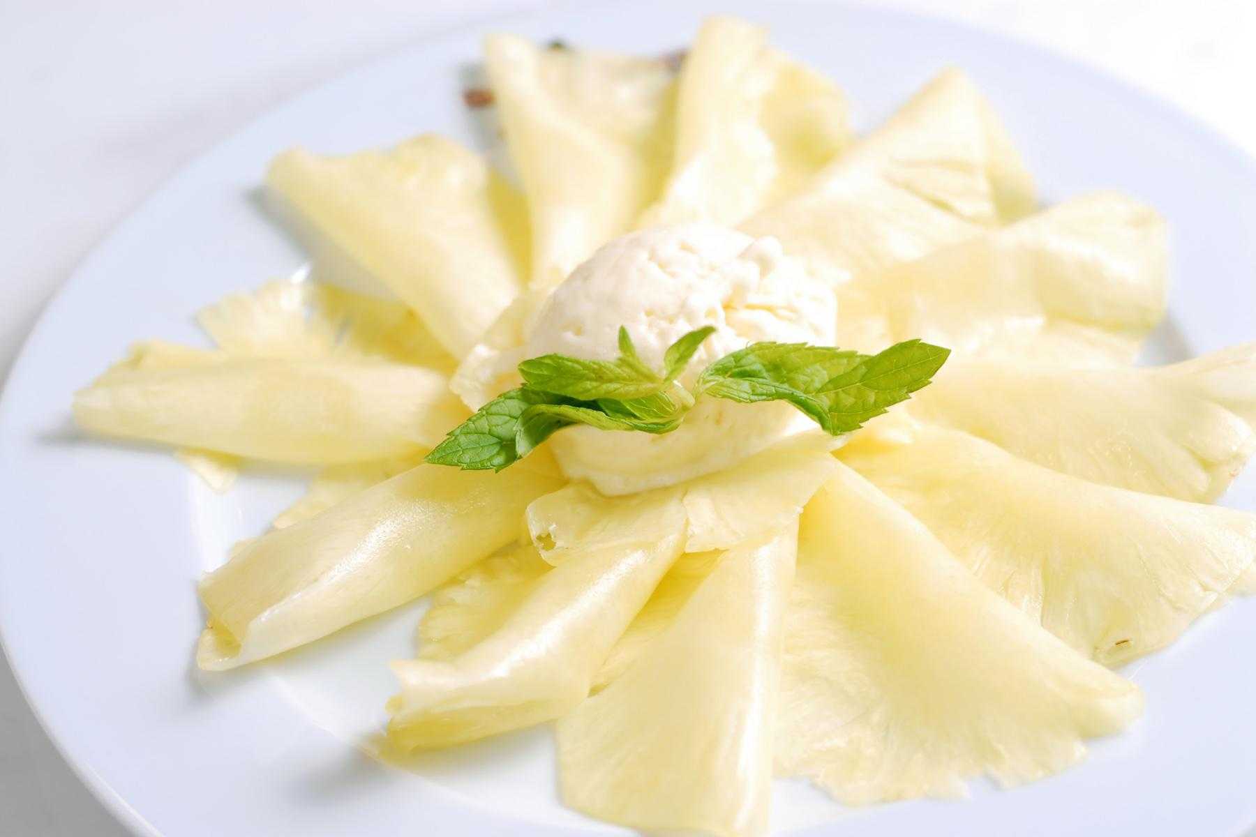 Thinly sliced pineapple on plate.