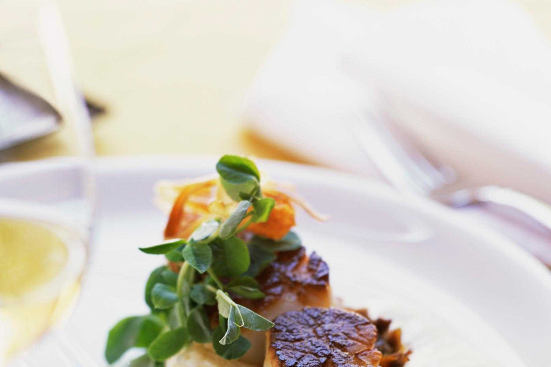 Close-up of seared scallop with wasabi oil.