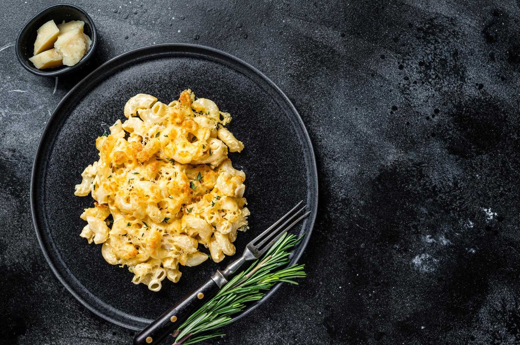 Overhead view of macaroni and cheese on a black plate.